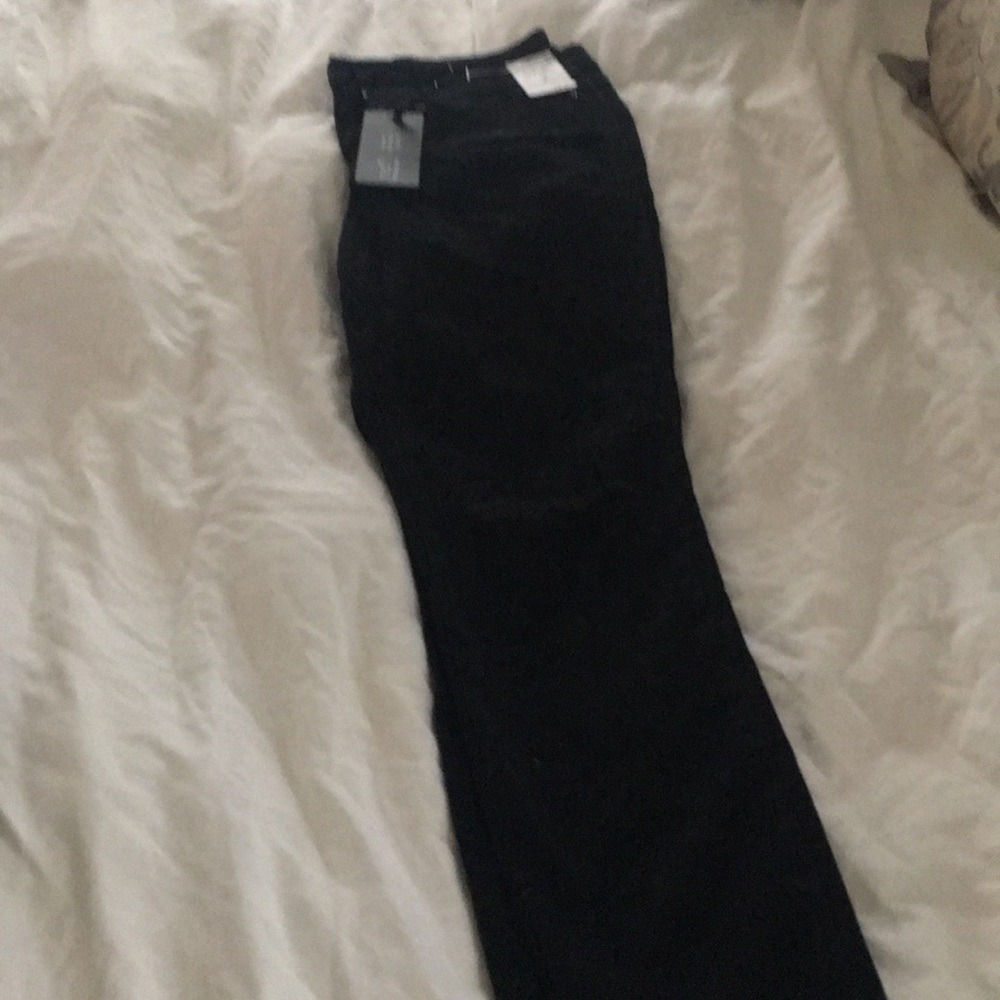 NEW. High rise black jeans. Ripped at knee